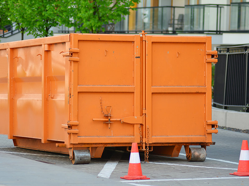 orange dumpster in parking lot long county ga